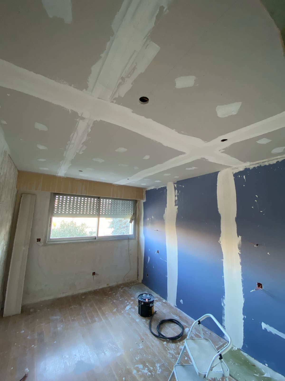 Chambre en chantier : faux plafond en plaques de plâtre et mur doublé en plaques de plâtre acoustiques, boîtiers électriques en attente